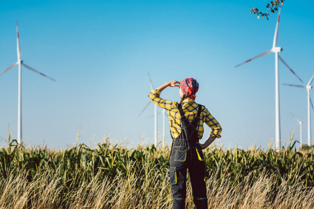 Farmer woman looks at wind turbines