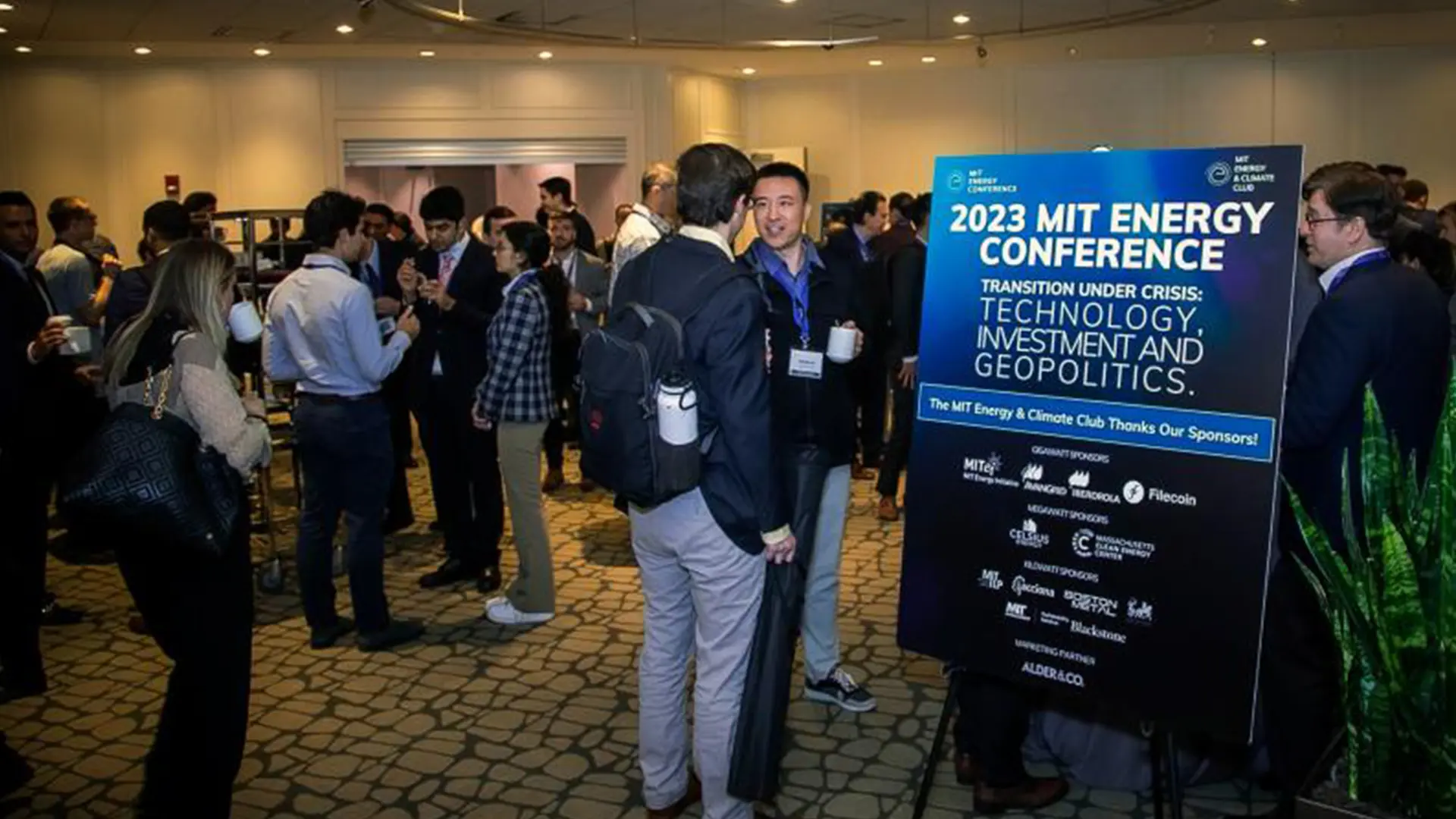 Attendees gather in groups, chatting at the 2023 MIT Energy Conference.